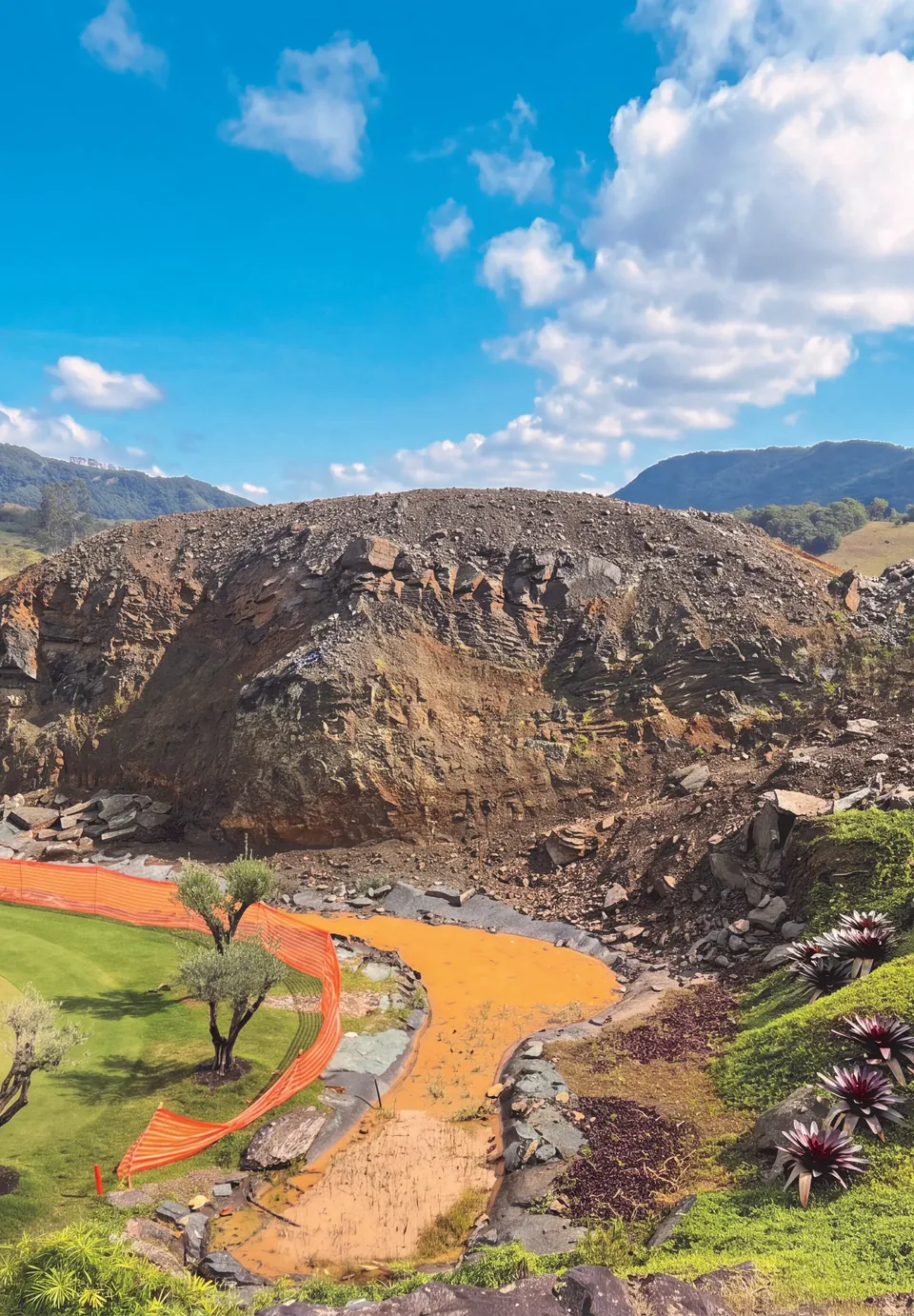 O talude reconstruído visto de baixo, com o riacho e a vegetação nativa