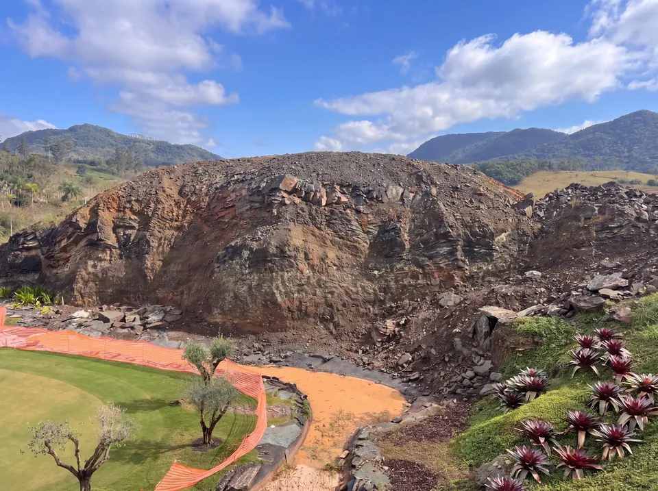 O morro refeito com moldes da própria rocha, entre o campo de golfe e o riacho