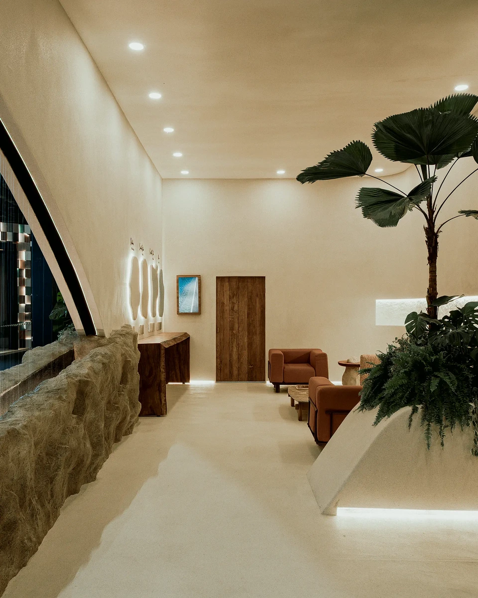 Interior do estande com parede de pedra, bancos e plantas